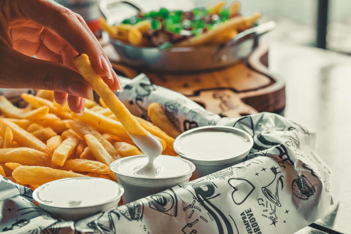 platter of chips being dipped in white dips