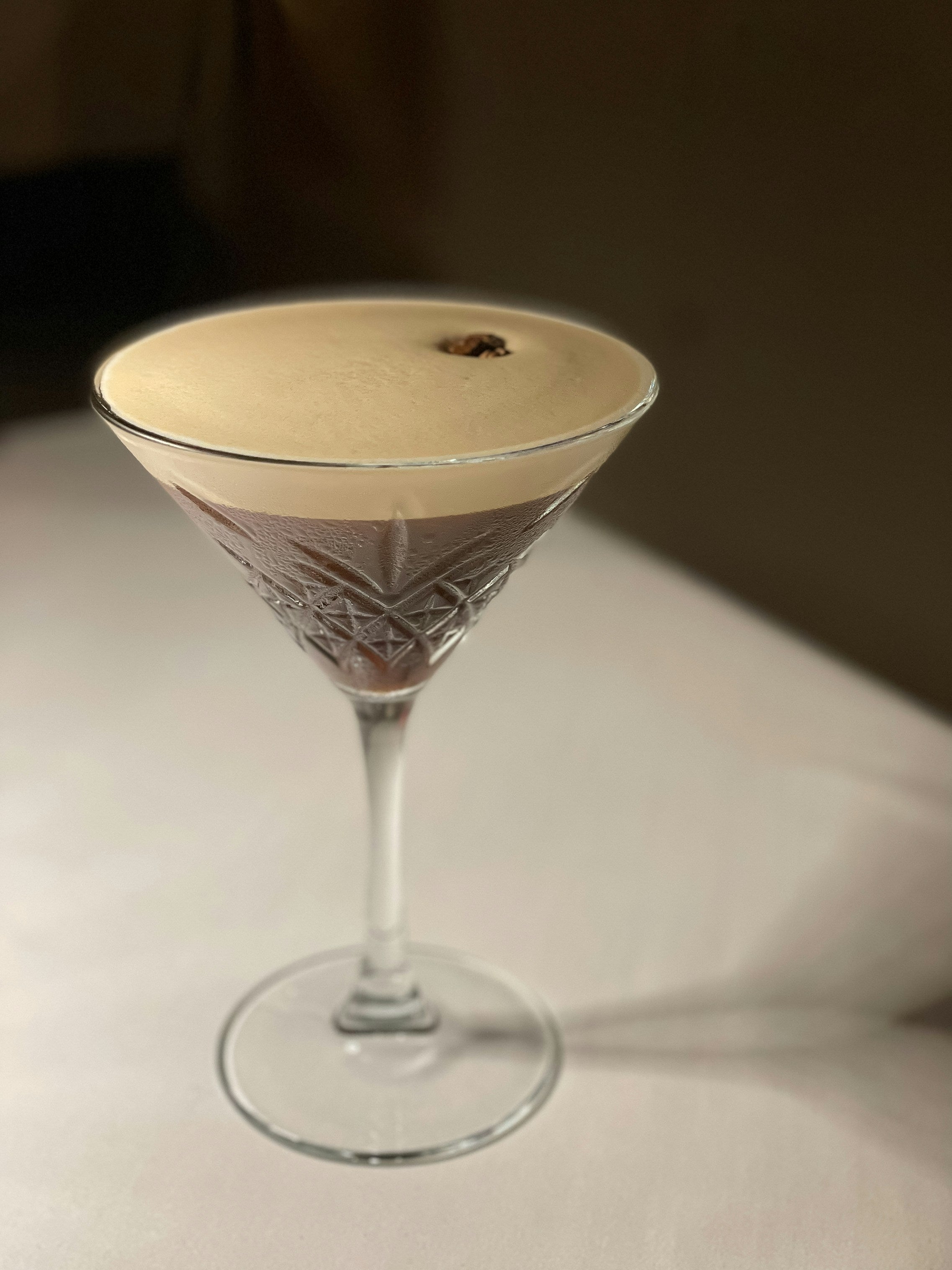 Classic Espresso Martini cocktail in a coupe glass with creamy foam top and coffee bean garnish.
