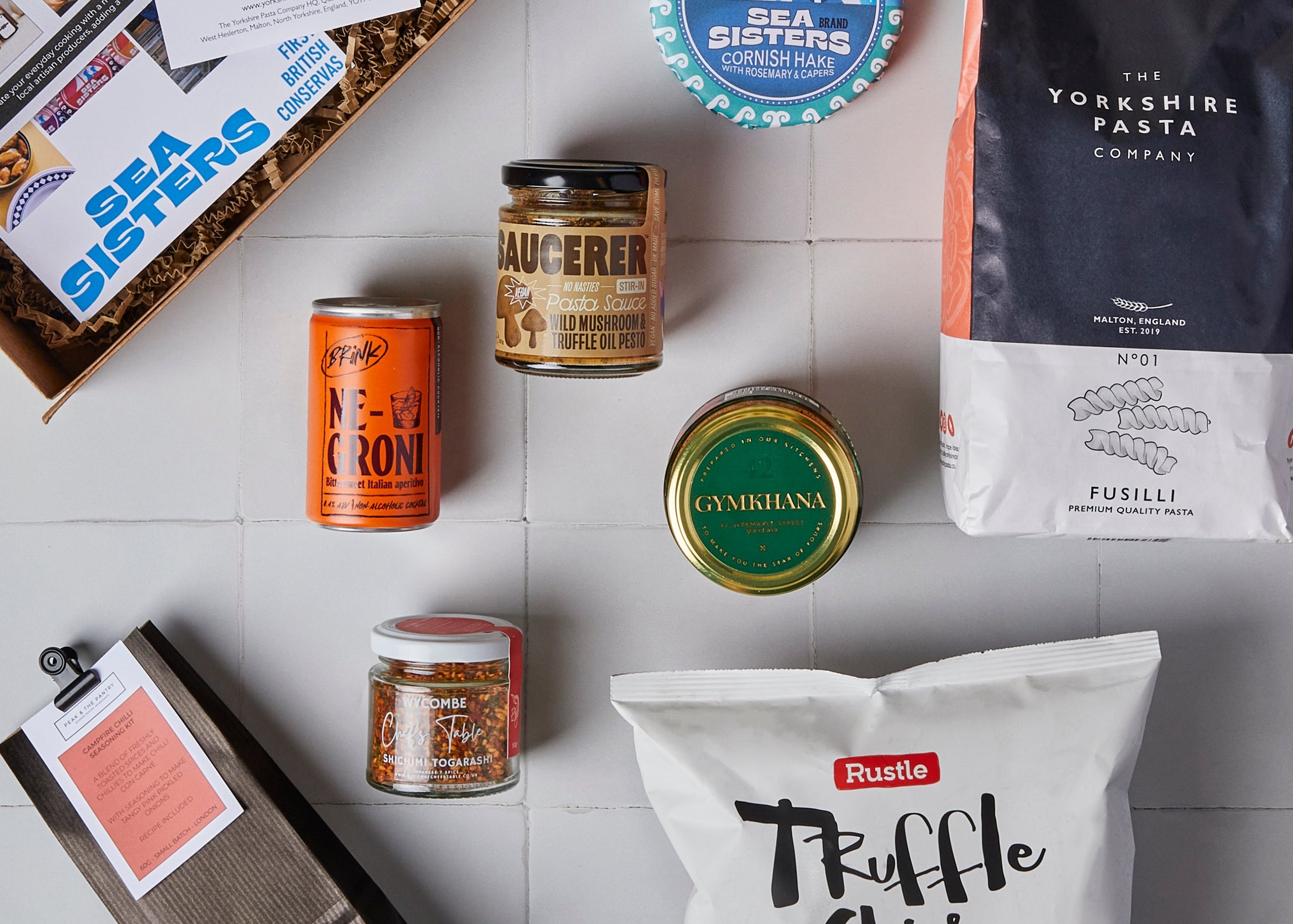 Translation missing: en.Collection of food products including a box, jars, and bags on a tiled surface: Pantry Staples