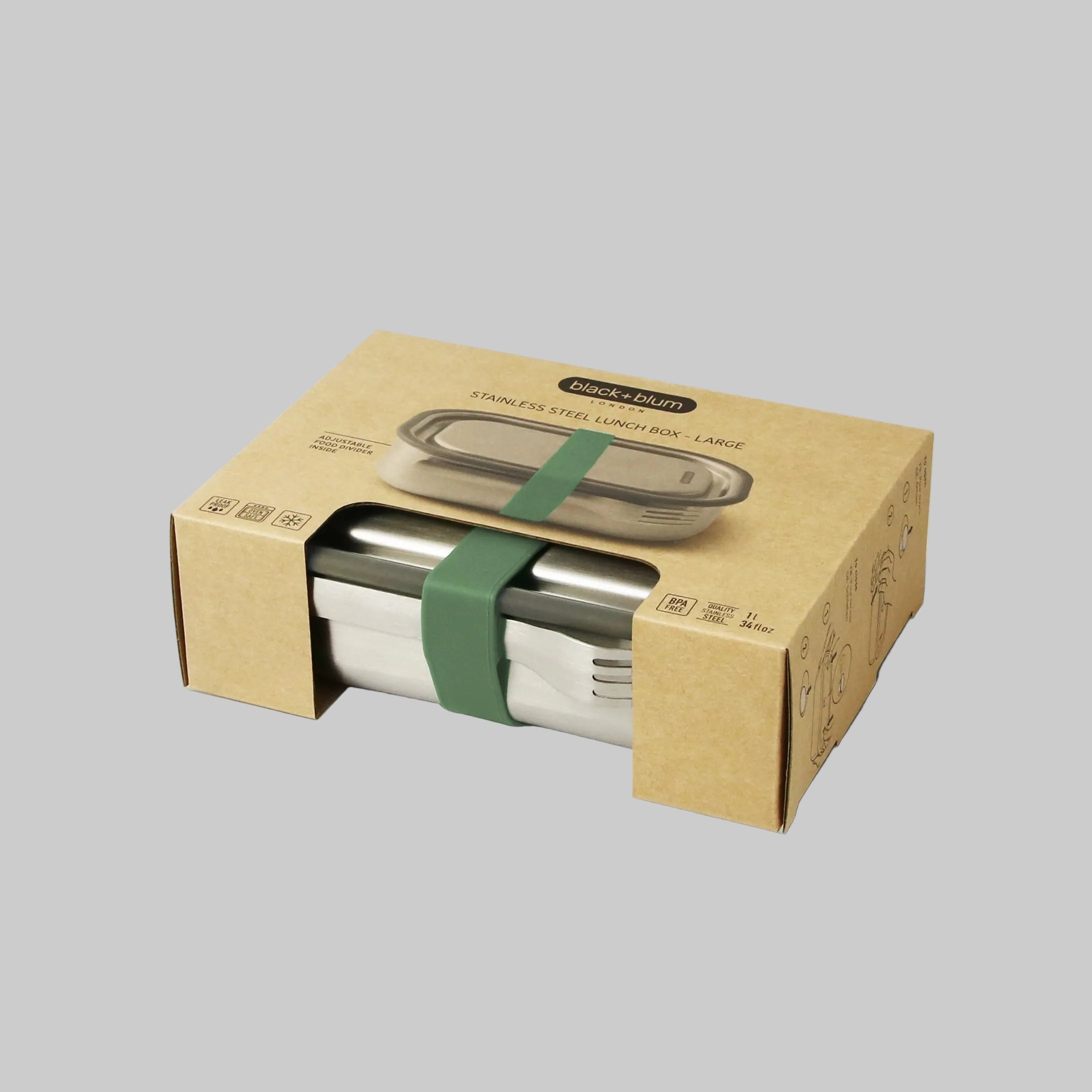 Stainless steel lunch box in a cardboard box with a green strap on a white background