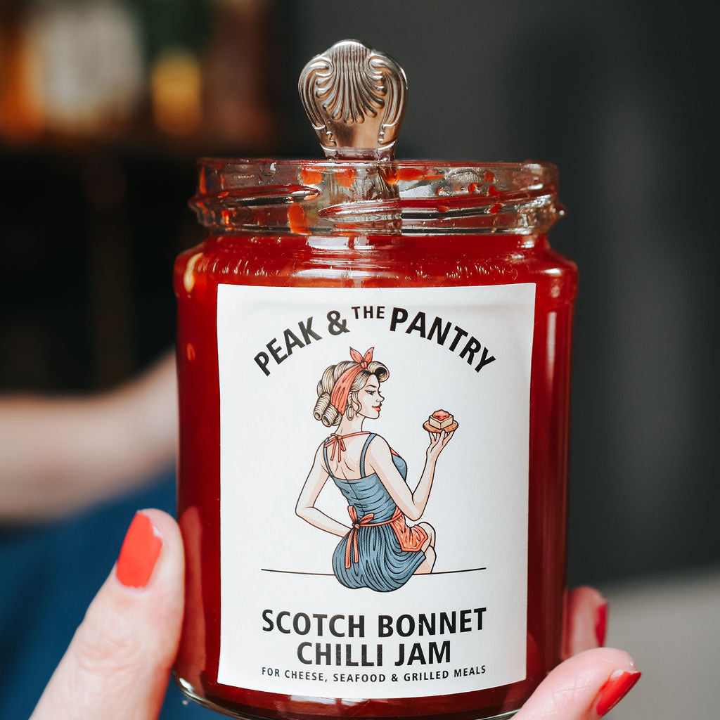 Jar of Peak & The Pantry Scotch Bonnet Chilli Jam held by a hand with red nail polish.