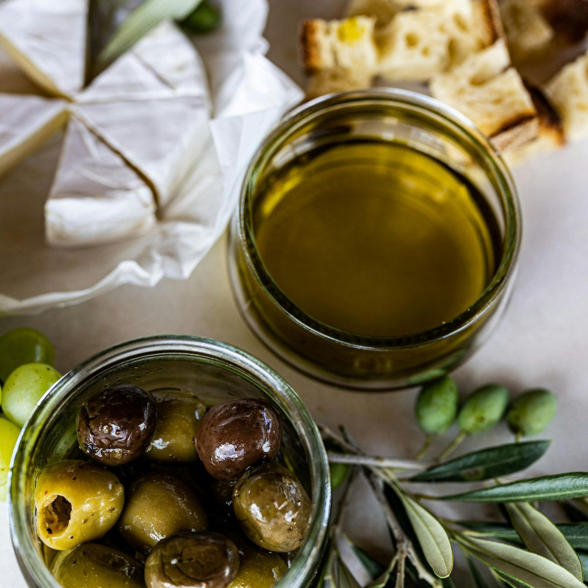 bowl olive oil with olives cheese and bread